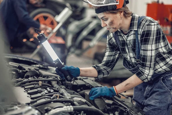 Meisje in een veiligheidshelm controleren van een radiator — Stockfoto