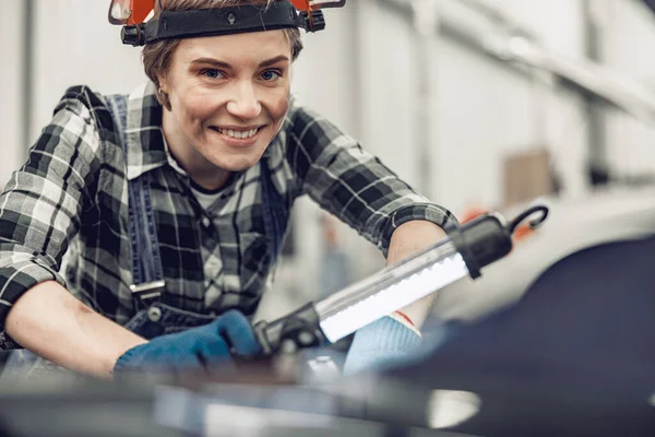 Mekaniker med ficklampa som arbetar i garage — Stockfoto