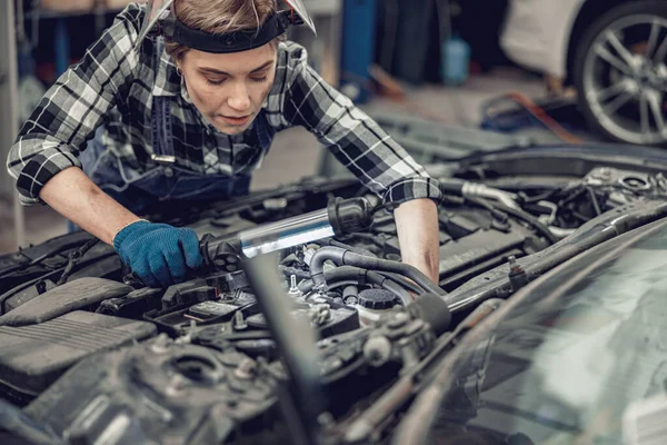 Blanke vrouwelijke werknemer die een personenauto repareert — Stockfoto