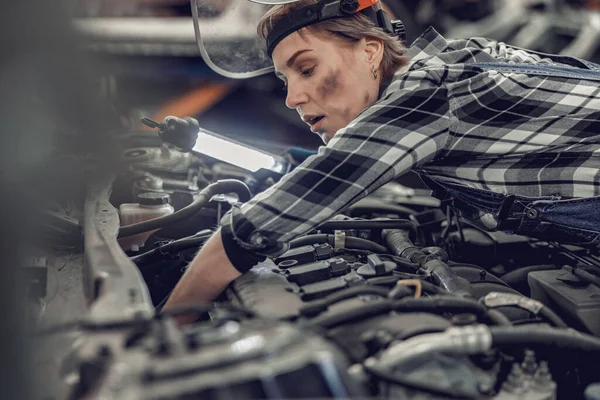 Mekaniker som reparerar en bil i en serviceverkstad — Stockfoto