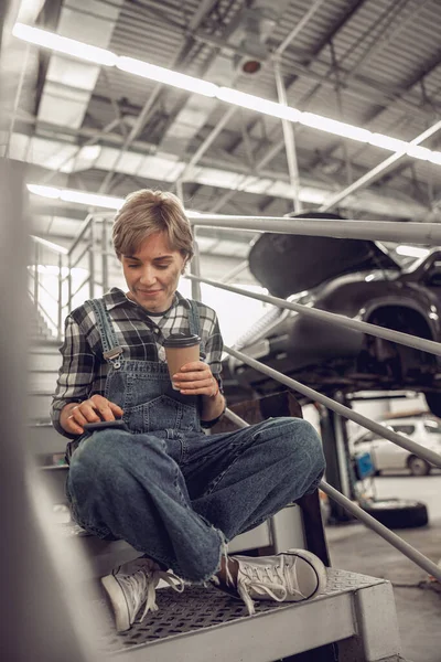 Attraktiv tekniker som använder sin gadget på jobbet — Stockfoto