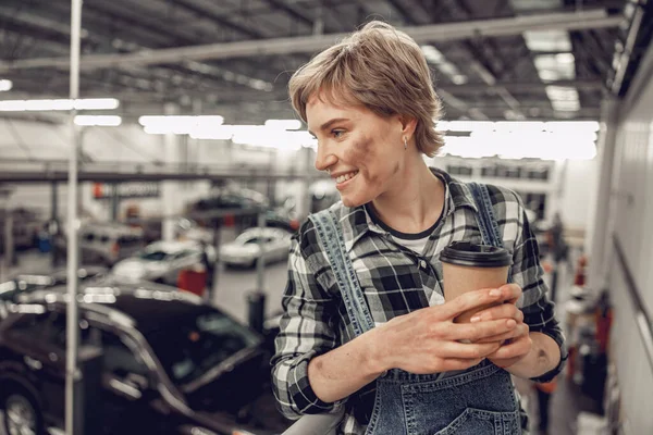 Vreugdevolle jonge monteur in een werkplaats — Stockfoto