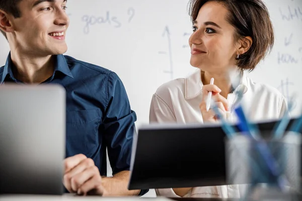 Sonriendo hombre y mujer mirándose en la oficina — Foto de Stock