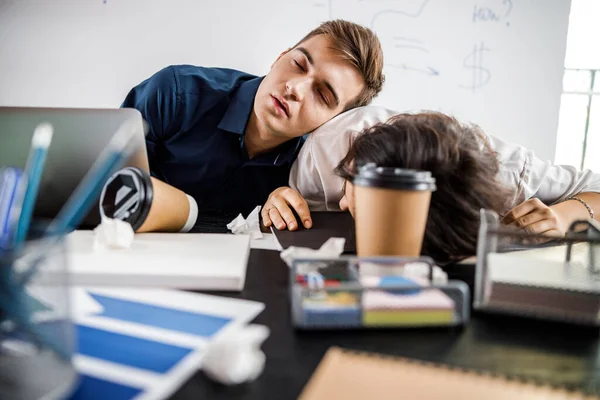 Dos trabajadores cansados sentados a la mesa — Foto de Stock