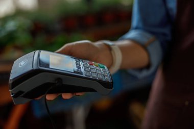 İçeride elektronik cihaz kullanan genç bir kadın.