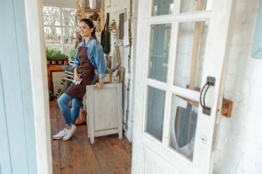 Gülümseyen genç kadın işyerinde dinleniyor.