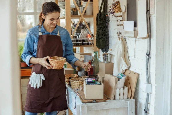 Pleasant young lady holding a wicker basket — Stock Photo, Image