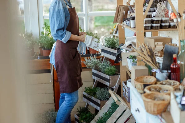 Mulher herbalist de pé perto de uma prateleira rack de madeira — Fotografia de Stock