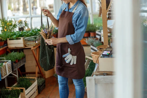 Menina colocando um buquê de trigo e lavanda em uma bolsa — Fotografia de Stock