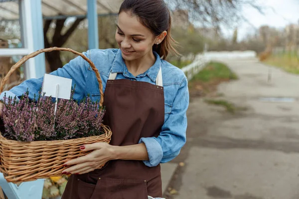 Pleased female botanist enjoying beautiful flowering plants — Stock Photo, Image