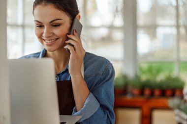 Kulağına cep telefonu dayanmış bir kız.