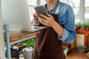 Beyaz kadın cep telefonunu kapalı mekanda kullanıyor.