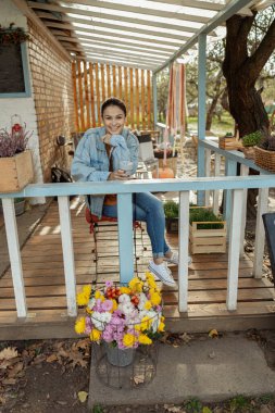 Neşeli genç bayan kameraya gülümsüyor.