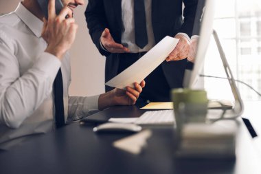 Erkek ofis çalışanları içeride belgelerle çalışıyorlar.