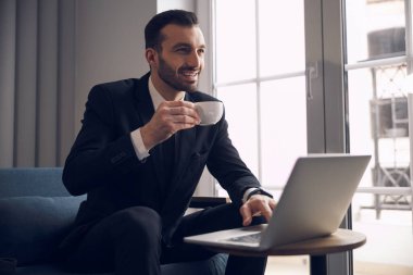 İçerideki bilgisayarda çalışan gülümseyen ofis çalışanı.
