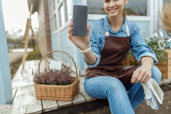 Donna con un cellulare in posa per la fotocamera — Foto Stock