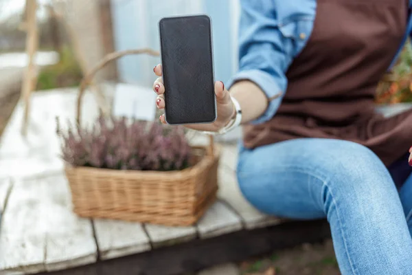 若い女性は屋外で彼女の携帯電話を実証 — ストック写真