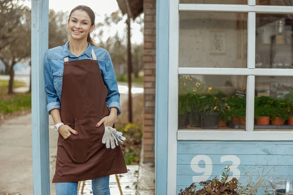 Joyeux jeune femme appuyé contre un poste — Photo