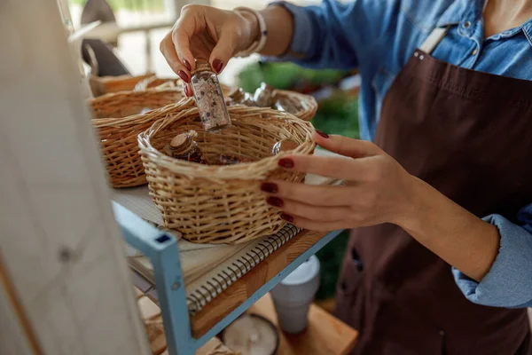 Herboriste sortant une petite bouteille d'un panier — Photo