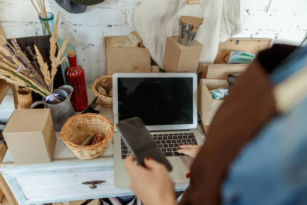 Meisje in een schort met behulp van een laptop — Stockfoto
