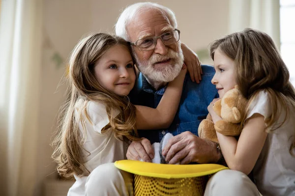 Grandpa playing with kids and looking inspired stock photo — Stock Photo, Image