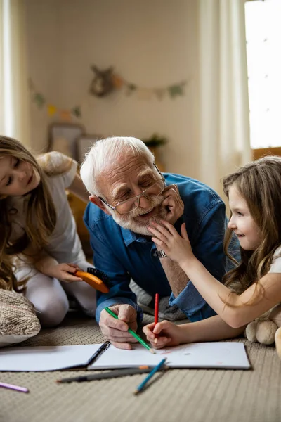 İkiz kızlar neşe dolu büyükbaba fotoğraflarıyla eğleniyorlar. — Stok fotoğraf