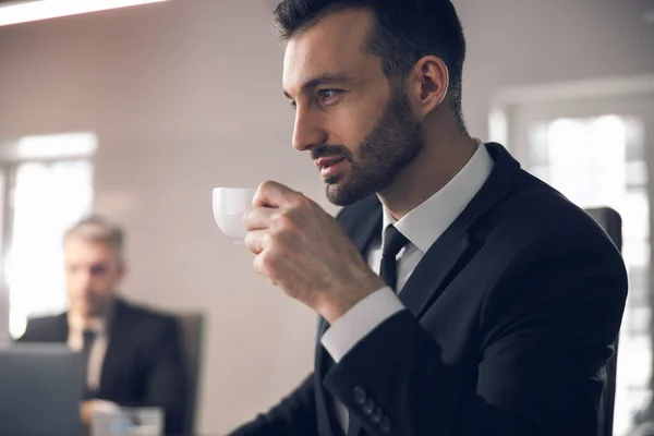 Uomo caucasico godendo di caffè sul posto di lavoro in ufficio — Foto Stock