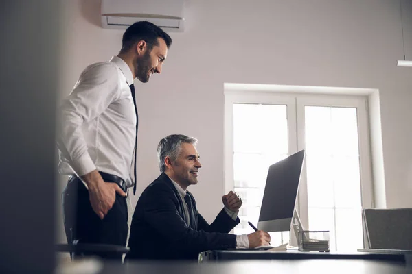 Felices colegas masculinos mirando la pantalla de la computadora portátil —  Fotos de Stock