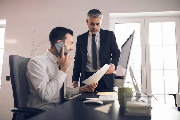 Caucasian office worker using mobile phone for work — Stock Photo, Image