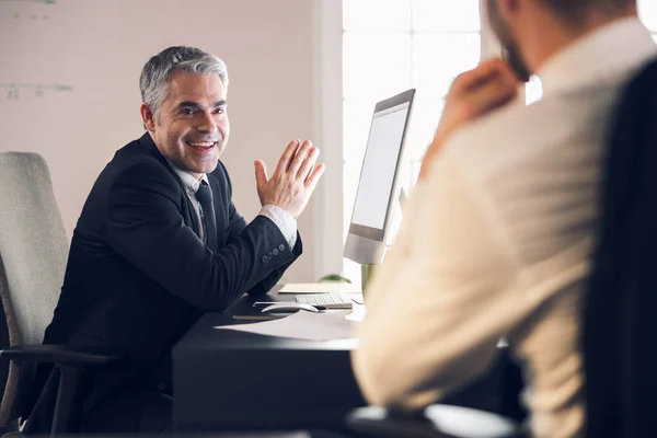 Usmívající se dospělý muž mluví se svým kolegou uvnitř — Stock fotografie