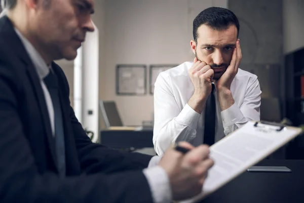 Nervöser junger Mann wartet in seinem Büro auf Ergebnisse — Stockfoto