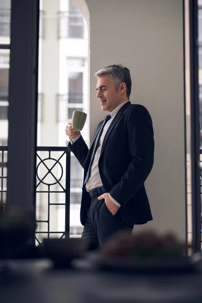 Кавказький бос насолоджується своїм напоєм з балкону. — стокове фото