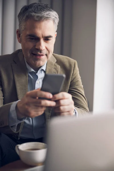 Vit leende man som skriver på sin telefon — Stockfoto