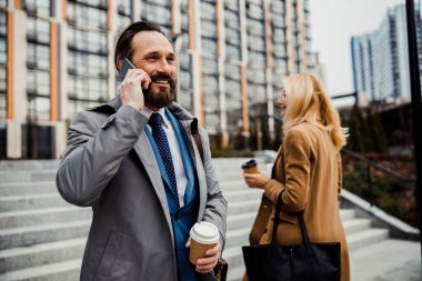 Gülümseyen erkek girişimci bir telefon görüşmesi yapıyor.