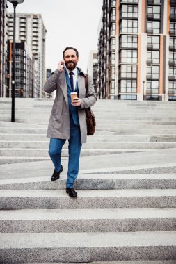 Elinde aletle merdivenlerden inen bir adam.