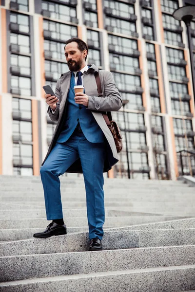 Enfocado moreno caucásico hombre de negocios utilizando su gadget — Foto de Stock