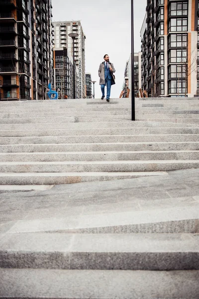 Uomo in impermeabile che scende le scale — Foto Stock