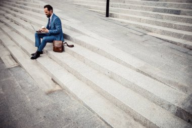 Dizüstü bilgisayarında yazan modern erkek girişimci.