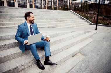 Uzun mesafeye bakan neşeli, kısa saçlı adam.