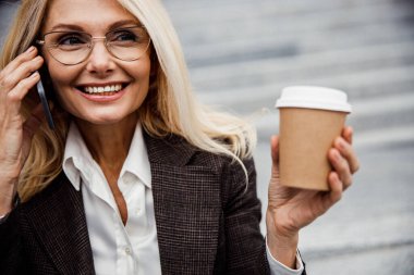 İş kadını dışarıdaki cep telefonundan arıyor.