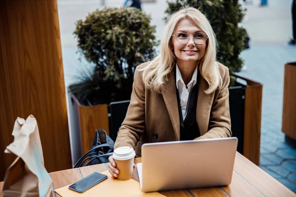 Mujer de negocios en una computadora portátil mirando a la distancia — Foto de Stock