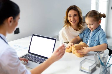 Hastanede çocuk doktoruna gülümseyen güzel bir anne.