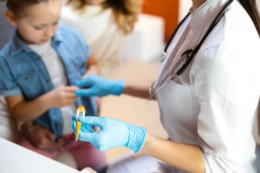 Kafkasyalı doktor sıcak klinikte termometreyi kolunda tutuyor.