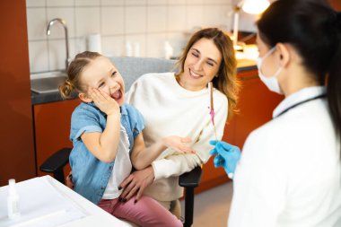 Kafkasyalı mutlu anne modern klinikte çocukla harika vakit geçiriyor.