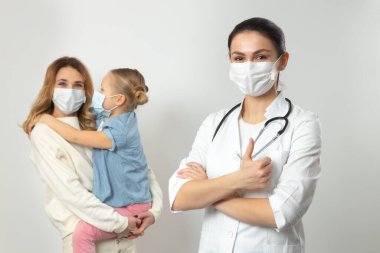 Anne ve kızı hastanede tıbbi maske takıyor.