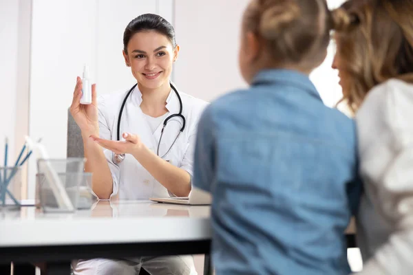 Médecin caucasien montrant bouteille avec médicament pour le traitement de petit patient — Photo