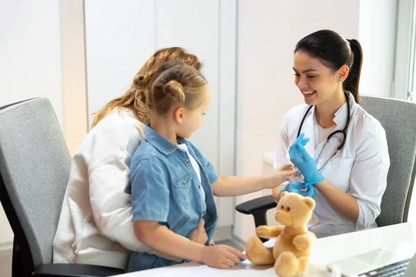 Kaukasischer Arzt in Gummihandschuhen wird kleinen Patienten untersuchen — Stockfoto