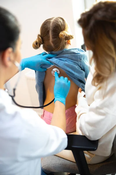 Pediatra femenina examina pequeña paciente en el hospital — Foto de Stock