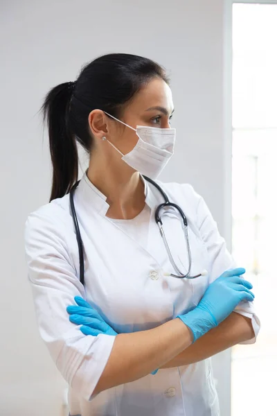 Caucásico bonito pediatra en máscara médica mirando a un lado — Foto de Stock