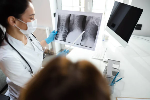 Pediatra caucásico mirando rayos X de columna vertebral en clínica moderna — Foto de Stock